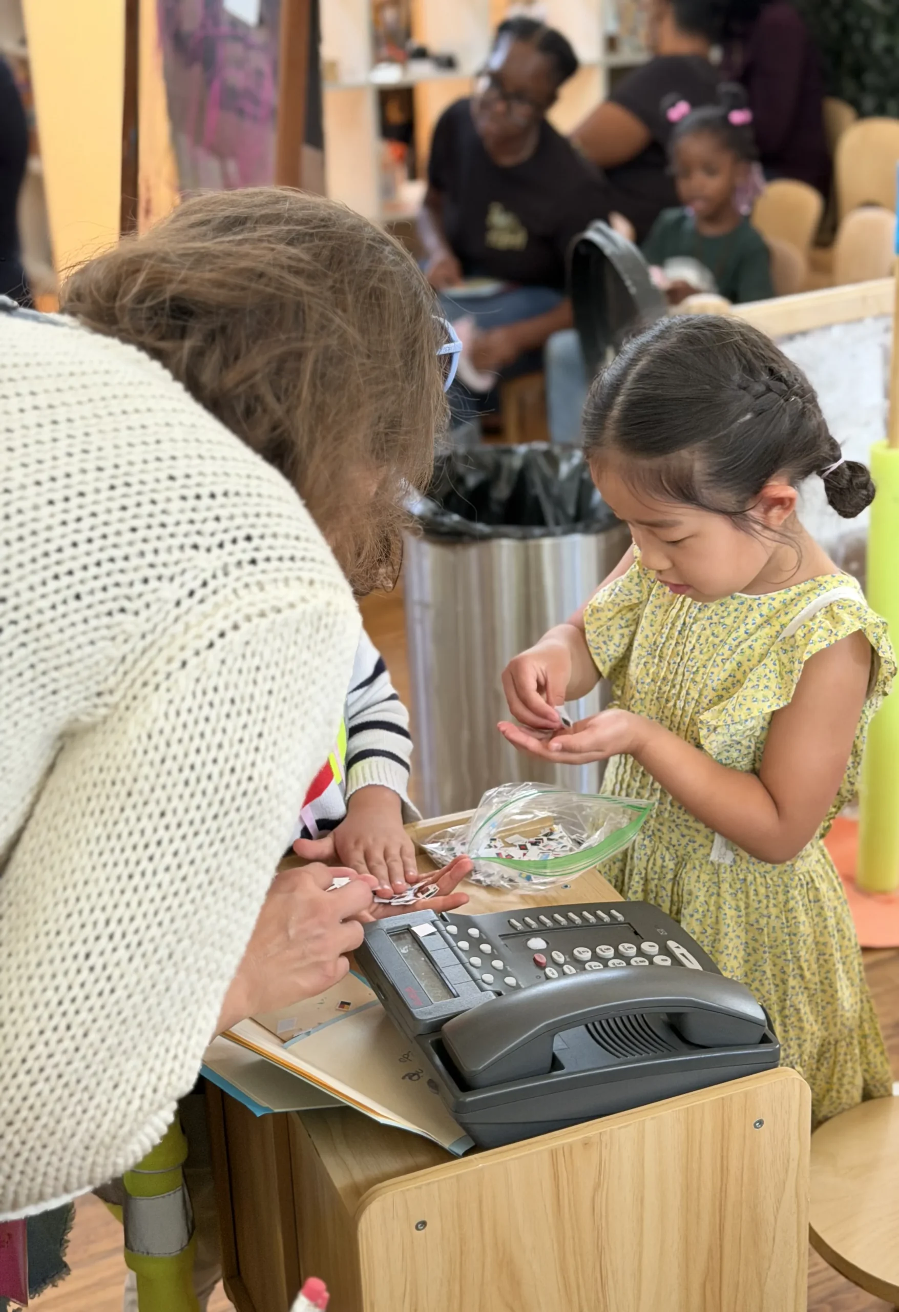 Teacher and child playing together at a classroom table